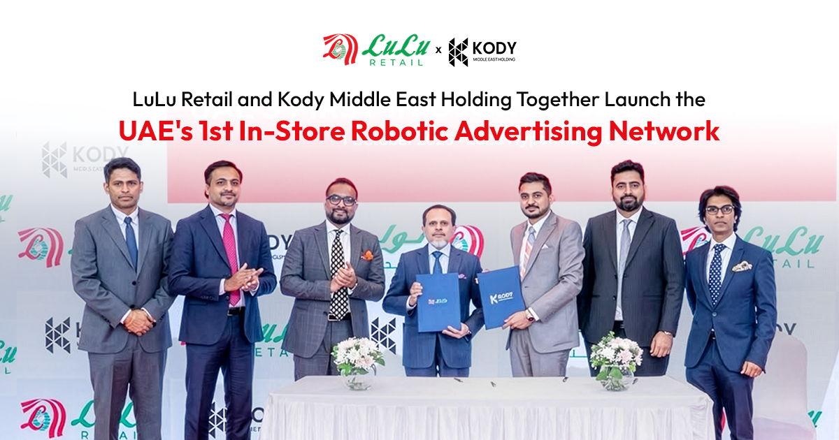 LuLu Retail and Kody Middle East Holding executives stand together holding signed documents to launch the UAE's 1st In-Store Robotic Advertising Network.